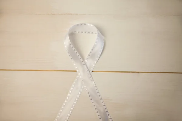 White ribbon on wooden desk — Stock Photo, Image