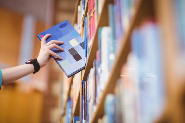 Studenten hand met smartwatch plukken boek uit boekenplank — Stockfoto