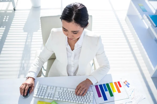 Businesswoman using her pc with documents — Stock Photo, Image