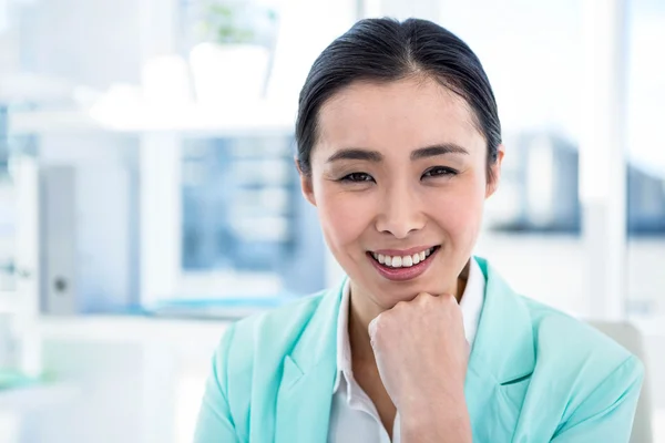 Mujer de negocios sonriente con notas en el escritorio —  Fotos de Stock