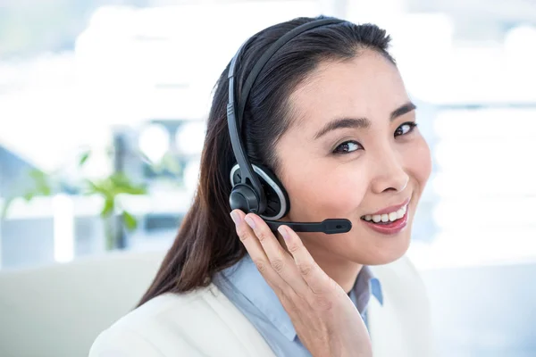 Mujer de negocios sonriente con auriculares — Foto de Stock