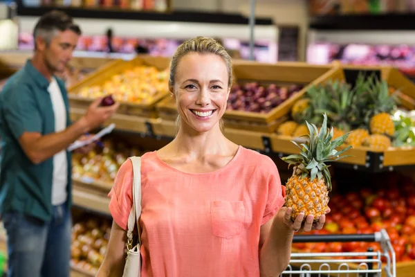 Donna sorridente che tiene un ananas — Foto Stock