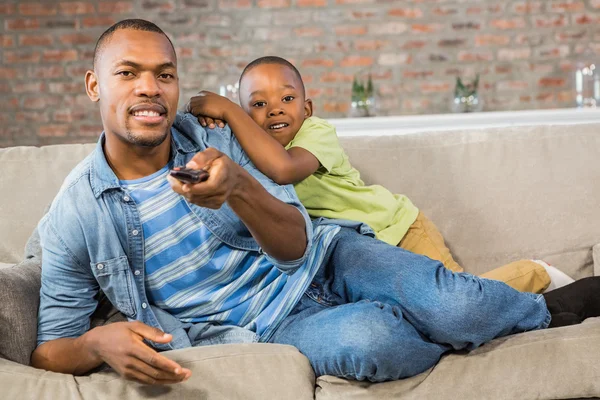 Padre e hijo viendo televisión juntos en el sofá —  Fotos de Stock