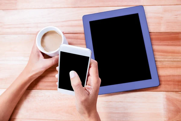 Zakenvrouw holding smartphone en koffiekopje — Stockfoto