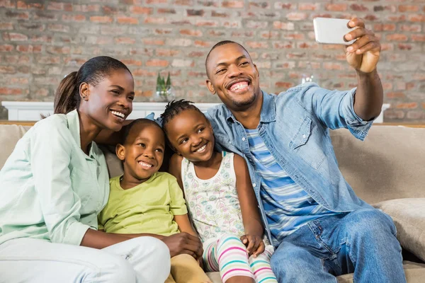 Familia feliz tomando una selfie en el sofá — Foto de Stock