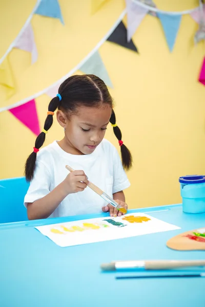 Girl painting with yellow and green colours — Stock Photo, Image