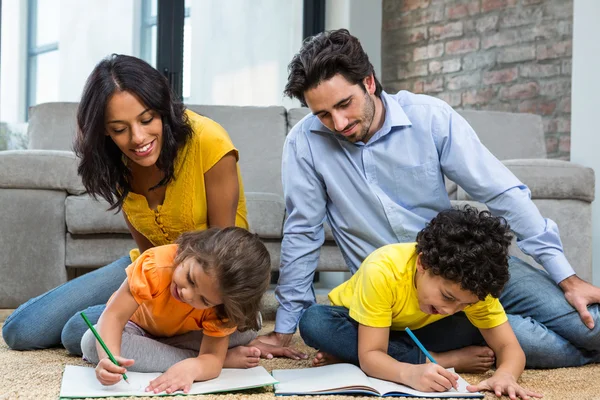 Famiglia seduta su moquette in soggiorno — Foto Stock