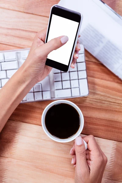 Empresaria sosteniendo teléfono inteligente y taza de café — Foto de Stock