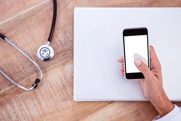 Lékař pomocí smartphone na dřevěný stůl — Stock fotografie