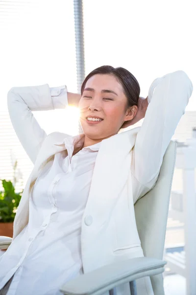 Mujer de negocios relajándose en su escritorio — Foto de Stock