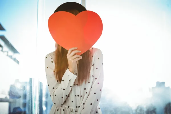 Attraente donna hipster dietro un cuore rosso — Foto Stock