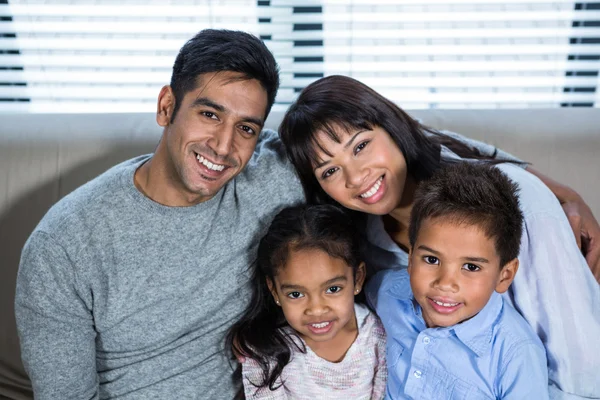 Joyeux jeune famille posant ensemble sur le canapé — Photo