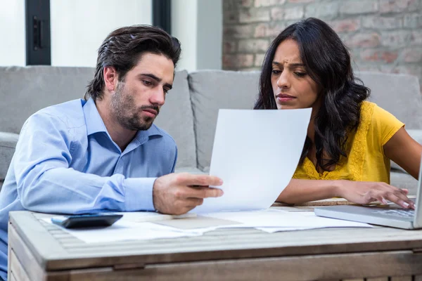 Ehepaar im Wohnzimmer bezahlt Rechnungen — Stockfoto