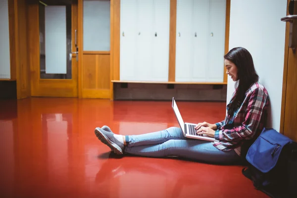 Χαμογελώντας φοιτητής κάθεται στο πάτωμα και χρησιμοποιώντας φορητό υπολογιστή — Φωτογραφία Αρχείου
