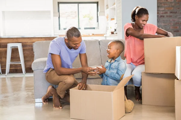 Family unwrapping things in new home — Stock Photo, Image