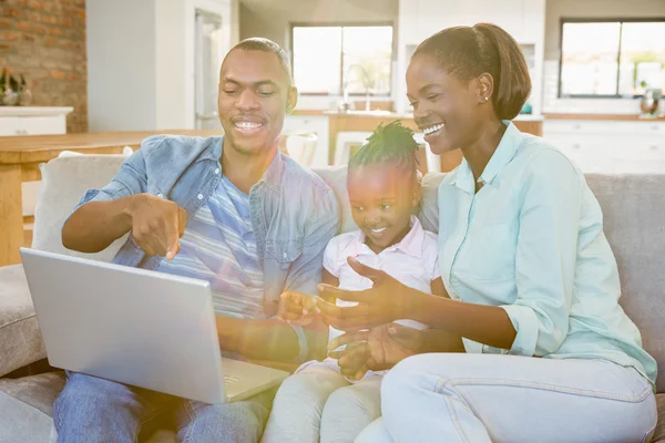 Ευτυχισμένη οικογένεια χρησιμοποιώντας φορητό υπολογιστή στον καναπέ — Φωτογραφία Αρχείου