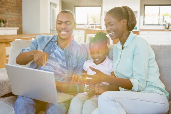 Happy family using laptop on the couch — Stock Photo, Image