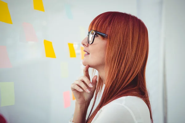 Attractive hipster woman looking at sticky notes — Stock Photo, Image