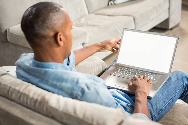 Over shoulder view of casual man using laptop — Stock Photo, Image