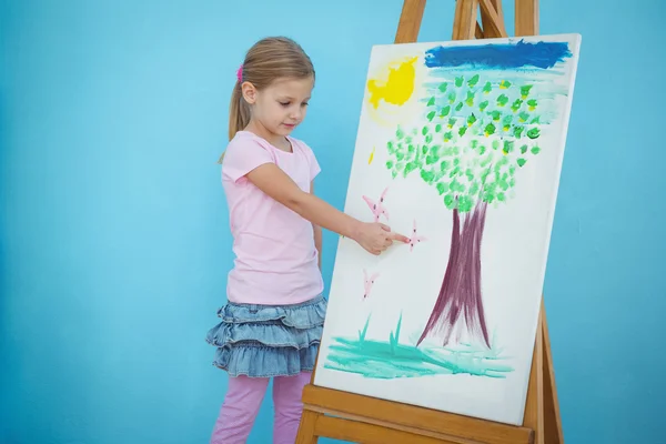 Smiling girl pointing to her picture — Stock Photo, Image