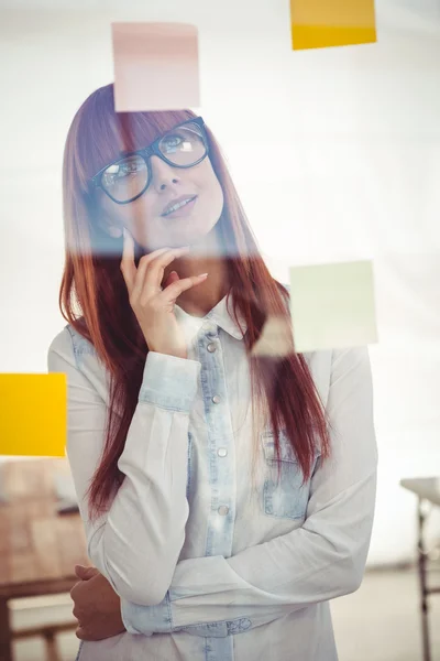 Mulher hipster atraente olhando para notas pegajosas — Fotografia de Stock