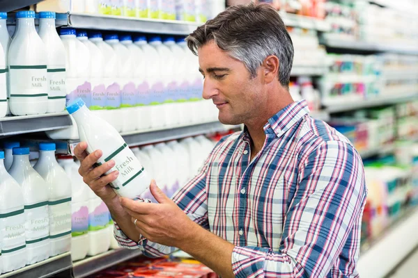 Tampan pria melihat botol susu — Stok Foto