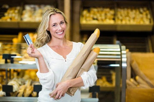 Mulher segurando pão e cartão de crédito — Fotografia de Stock