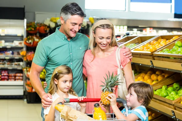 Jonge familie achter hun trolley — Stockfoto