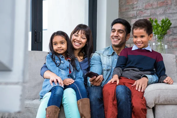 Joyeux jeune famille regarder la télévision — Photo