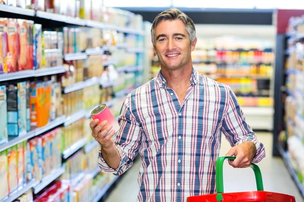 Smiling man holding can — Stock Photo, Image