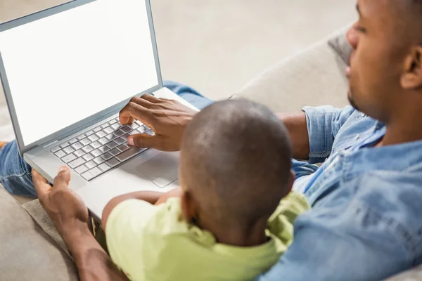 父亲和儿子在沙发上使用笔记本电脑 — 图库照片