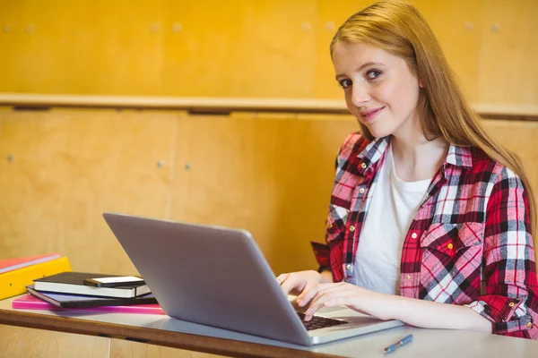 Lachende student met behulp van laptop en smartphone — Stockfoto