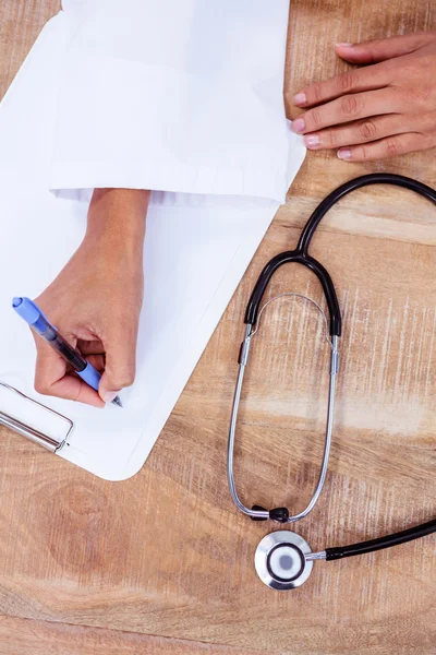 Doctor writing on clipboard — Stock Photo, Image
