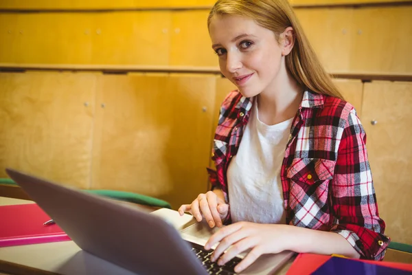 Усміхнений студент використовує ноутбук і смартфон — стокове фото