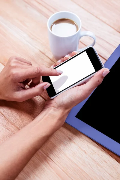 Businesswoman using her smartphone on desk — Stock Photo, Image