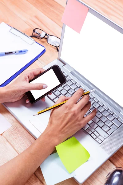 Vrouwelijke handen met smartphone en potlood — Stockfoto