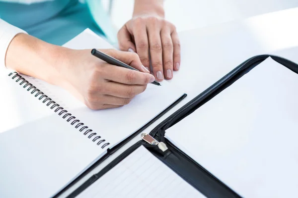 Businesswoman writing into notepad — Stock Photo, Image