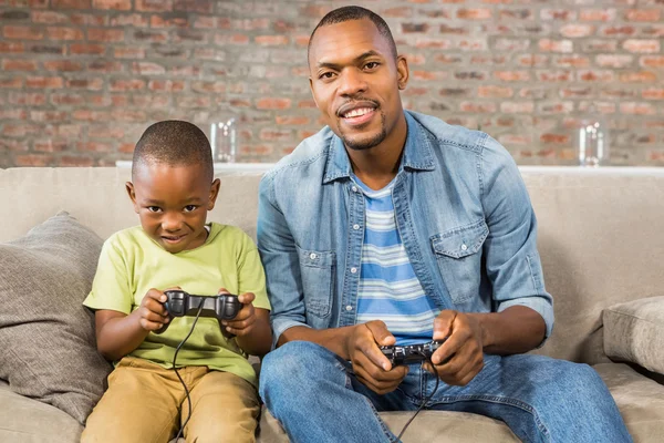Отец и сын вместе играют в видеоигры — стоковое фото