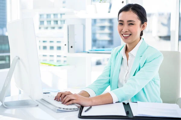 Smiling businesswoman with notes at desk Stock Photo