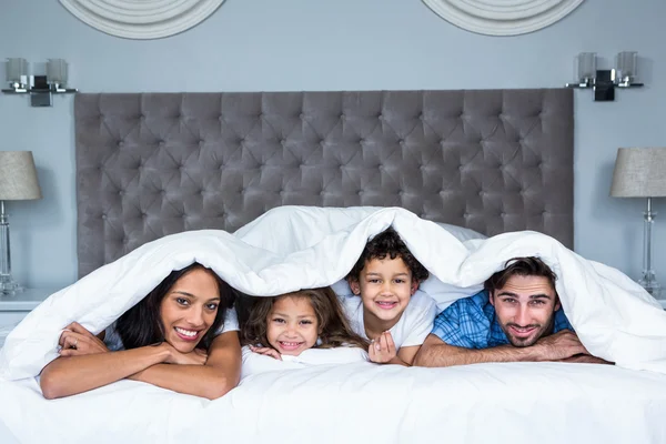 Gelukkige familie onder de deken — Stockfoto