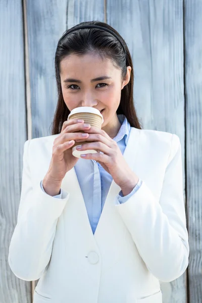Donna d'affari sorridente con caffè da asporto — Foto Stock
