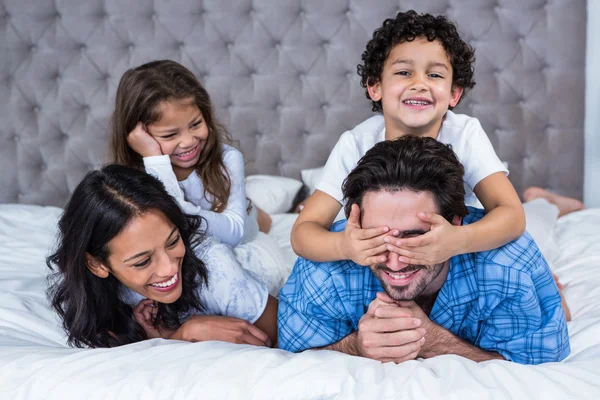 Gülümseyen aile yatağa atma — Stok fotoğraf