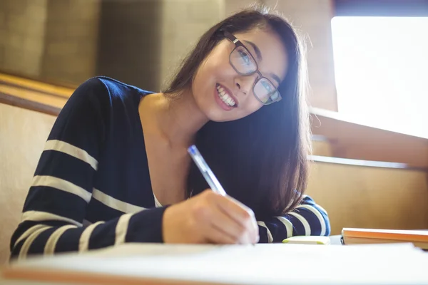 Estudiante sonriente escribiendo en cuaderno — Foto de Stock