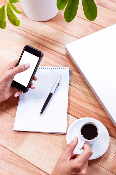 Weibliche Hände mit Smartphone und schwarzem Espresso — Stockfoto