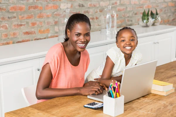 Carino figlia utilizzando computer portatile alla scrivania con la madre — Foto Stock