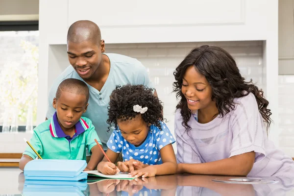 Padres ayudando a los niños a hacer la tarea — Foto de Stock