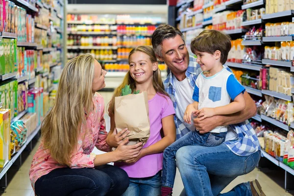 Счастливая семья в супермаркете — стоковое фото