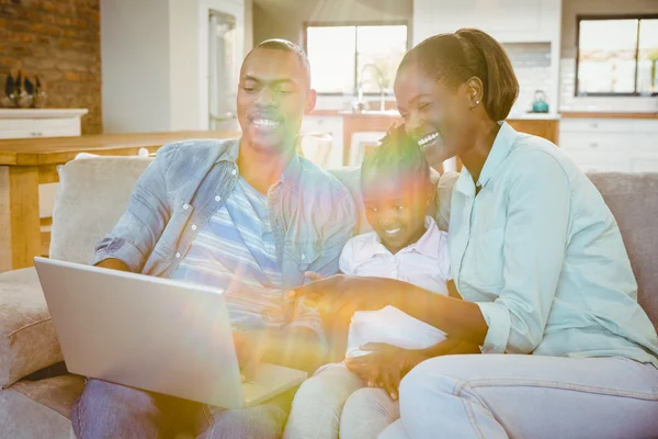 Família feliz usando laptop no sofá — Fotografia de Stock
