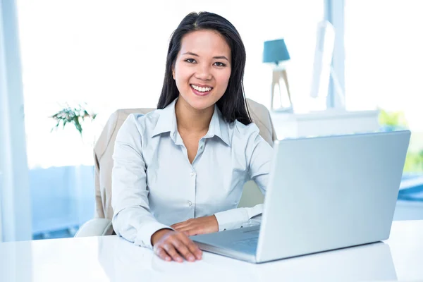 Gülümseyen iş kadını dizüstü bilgisayar kullanıyor. — Stok fotoğraf