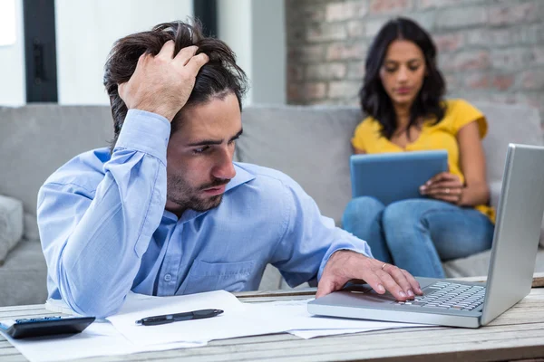 Besorgter Mann bezahlt Rechnungen im Wohnzimmer — Stockfoto